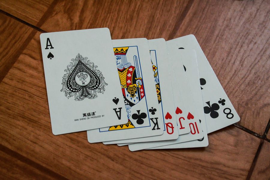 Kartu remi tersebar di atas meja kayu