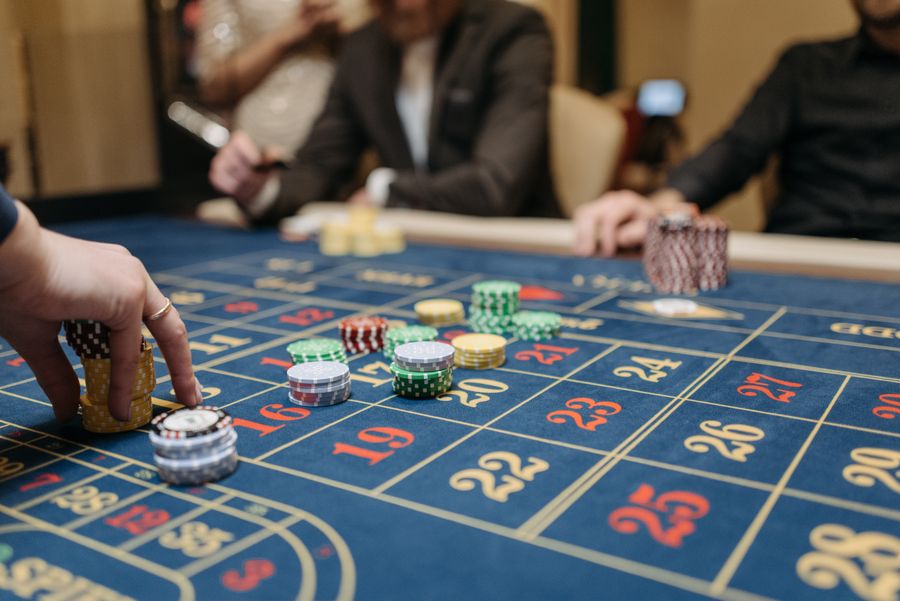 Tangan pemain menempatkan chip di atas meja roulette